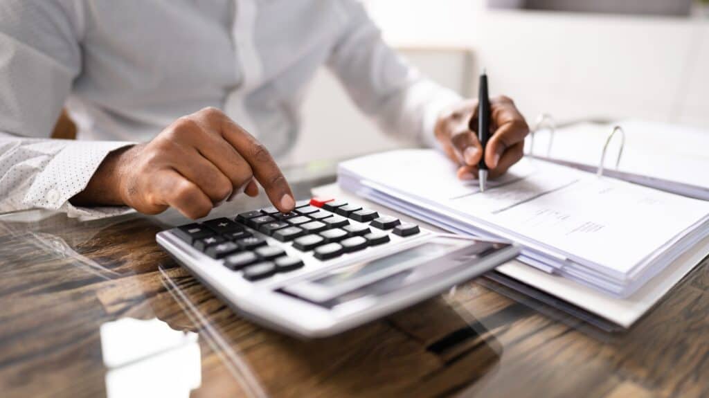 man saving money using a calculator
