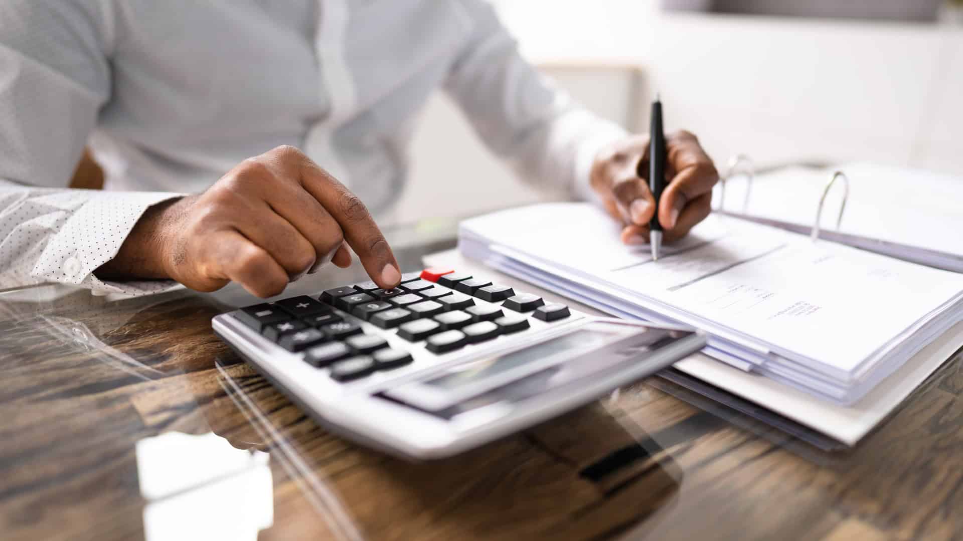 man saving money using a calculator