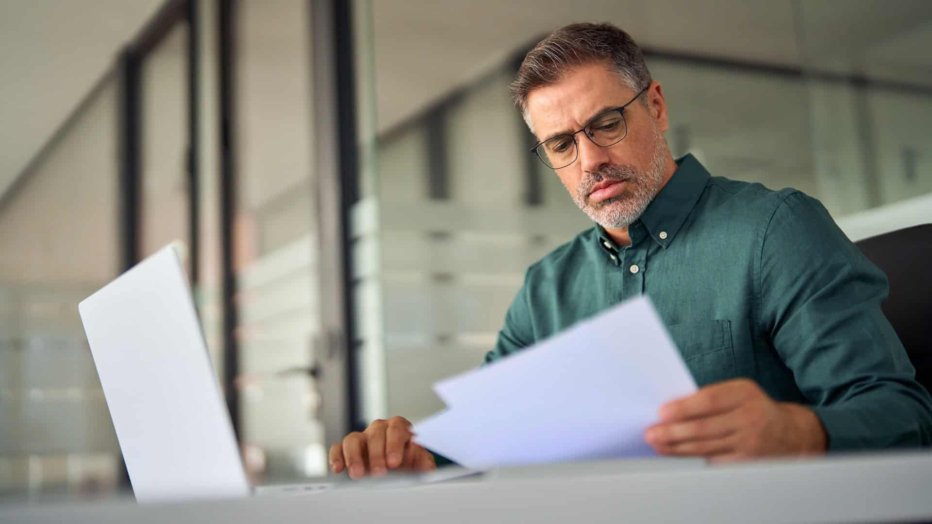 man doing his taxes on a laptop