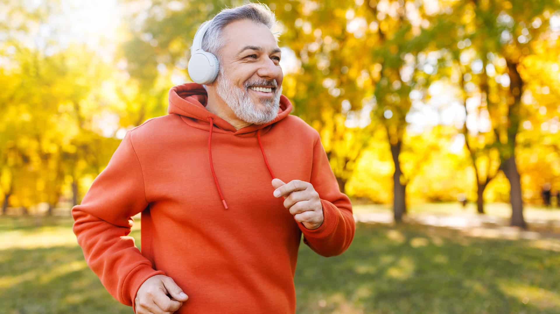Older man running outside with headphones