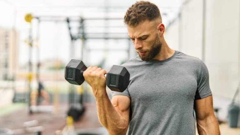 man lifting dumbbells in a gym