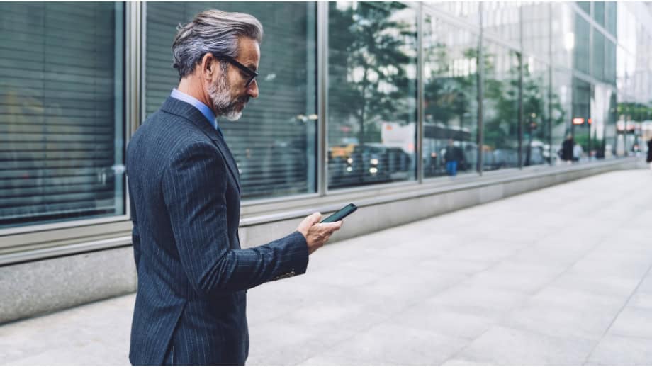 man in suit looking at phone.