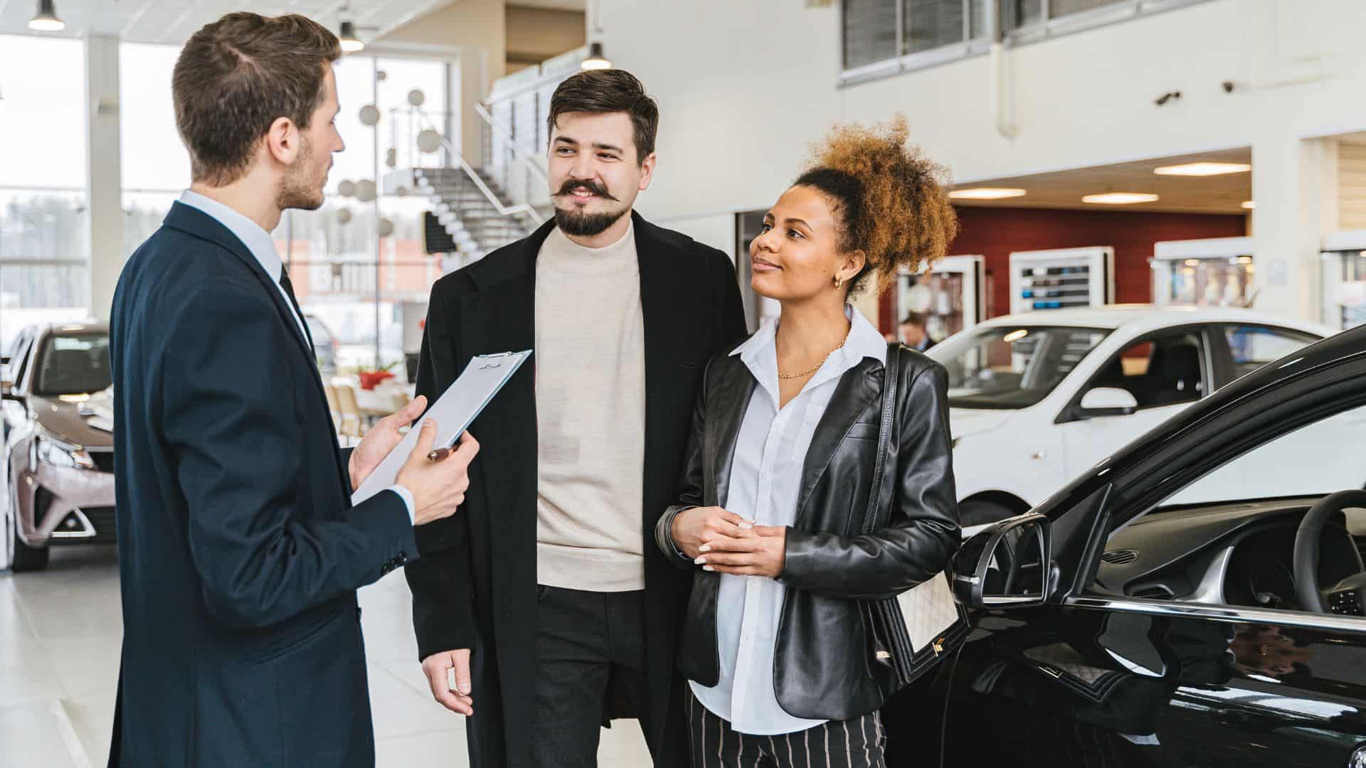 Couple at car dealership.