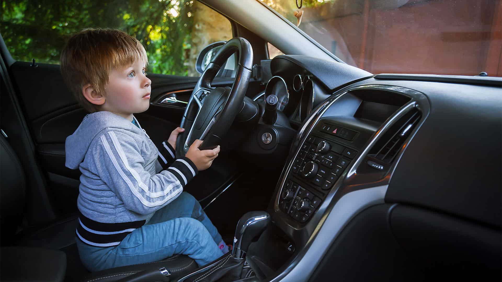 A young boy is driving a car.