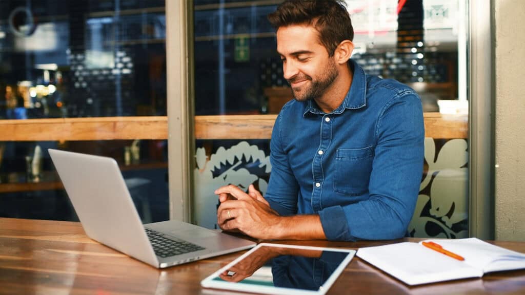 man work on laptop at a cafe