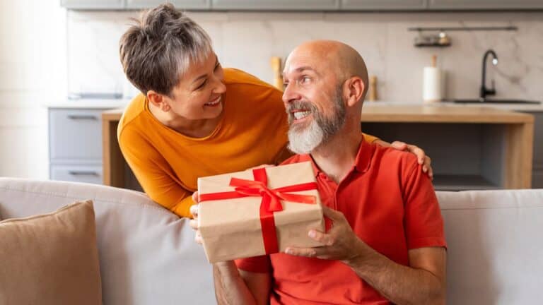 woman giving gift to her husband
