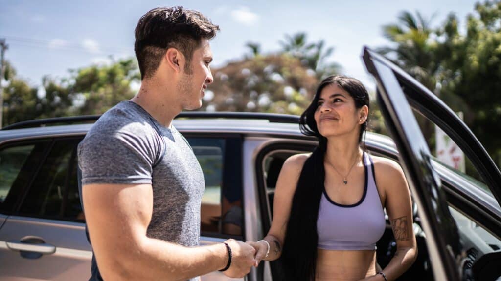 Man helping woman out of car