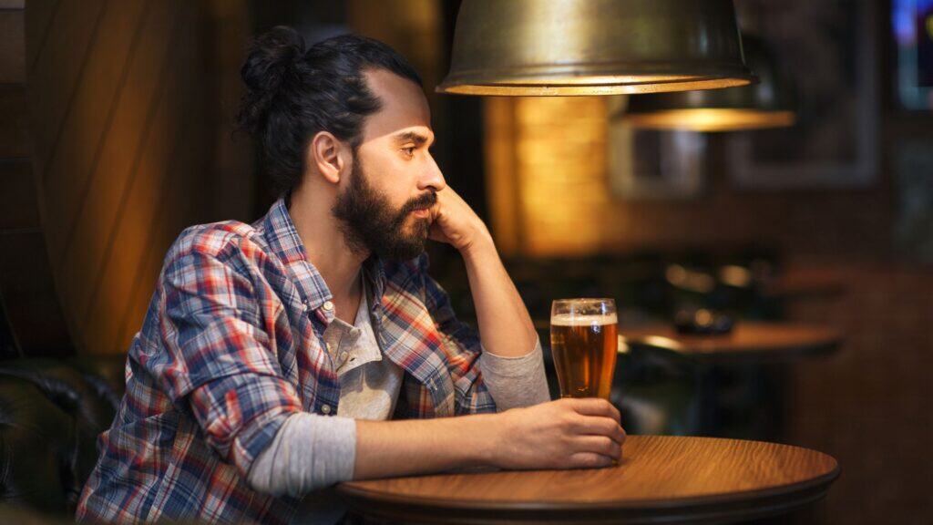 Man sitting alone in bar feeling lonely