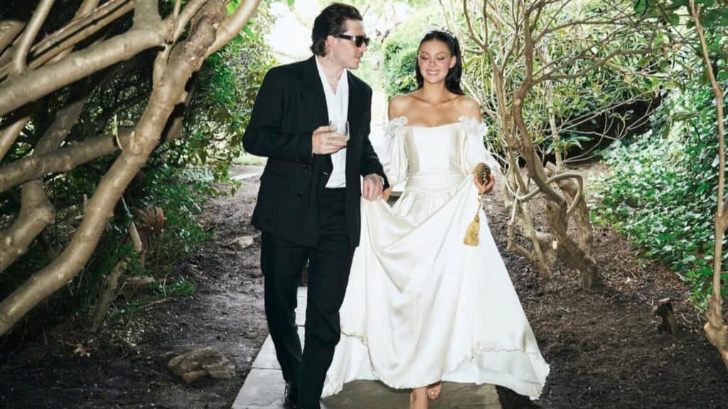 Brooklyn and Nicola Beckham at their wedding walking down tree-covered road