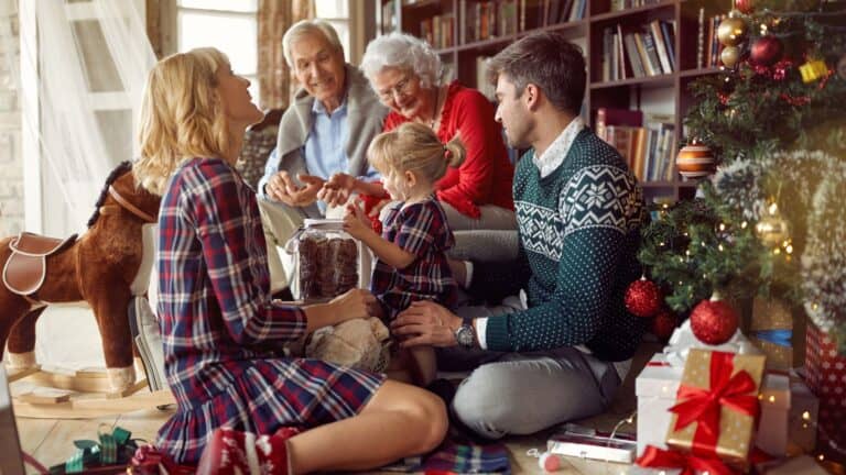 Joyful family celebrating Christmas together in cozy living room with decorated tree and gifts.