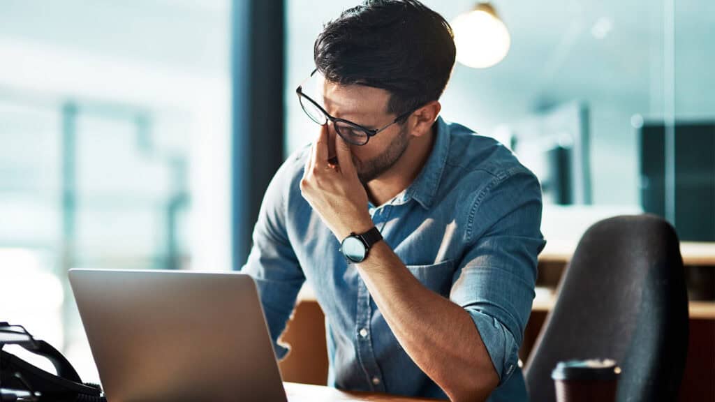 Man headache burnout in office.
