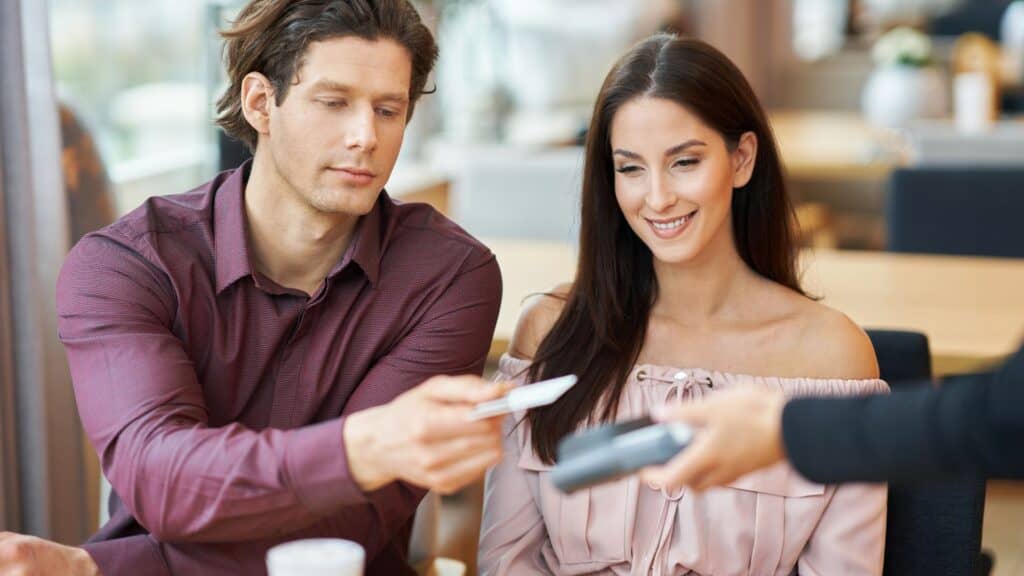Young Couple paying by credit card in Cafe