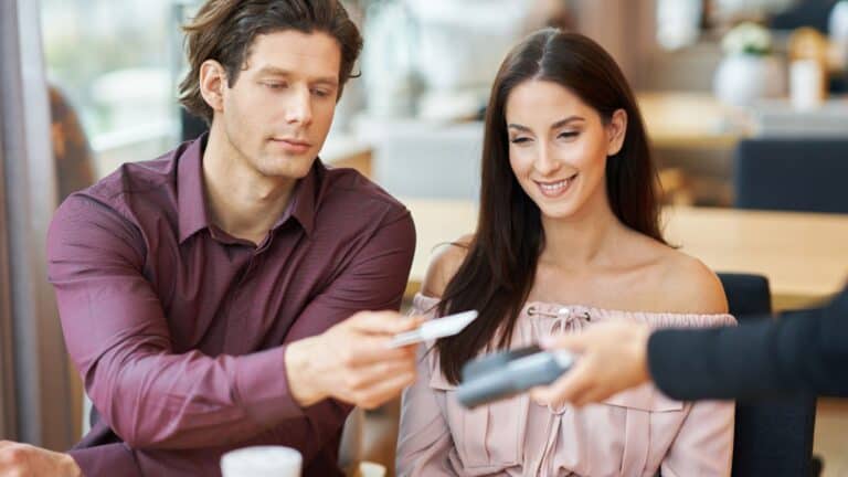 Young Couple paying by credit card in Cafe