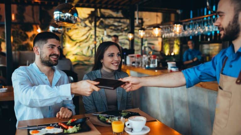 man paying bill with cash in restaurant