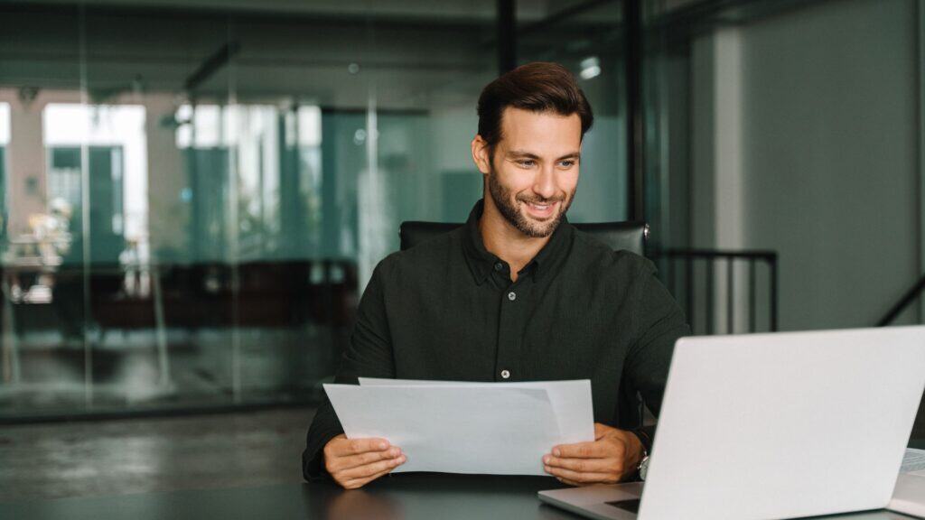 Young man sitting at his desk looking at laptop