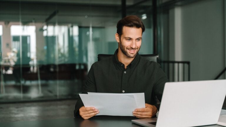 Young man sitting at his desk looking at laptop