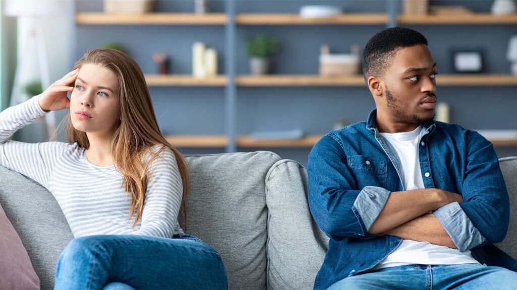 A couple argues on the sofa.