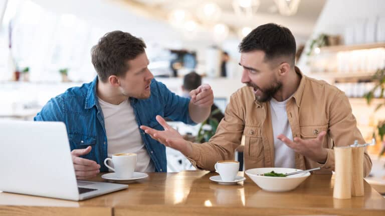 two men argue in a restaurant.