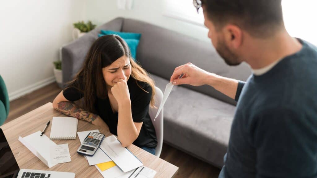woman crying with her husband while doing their taxes