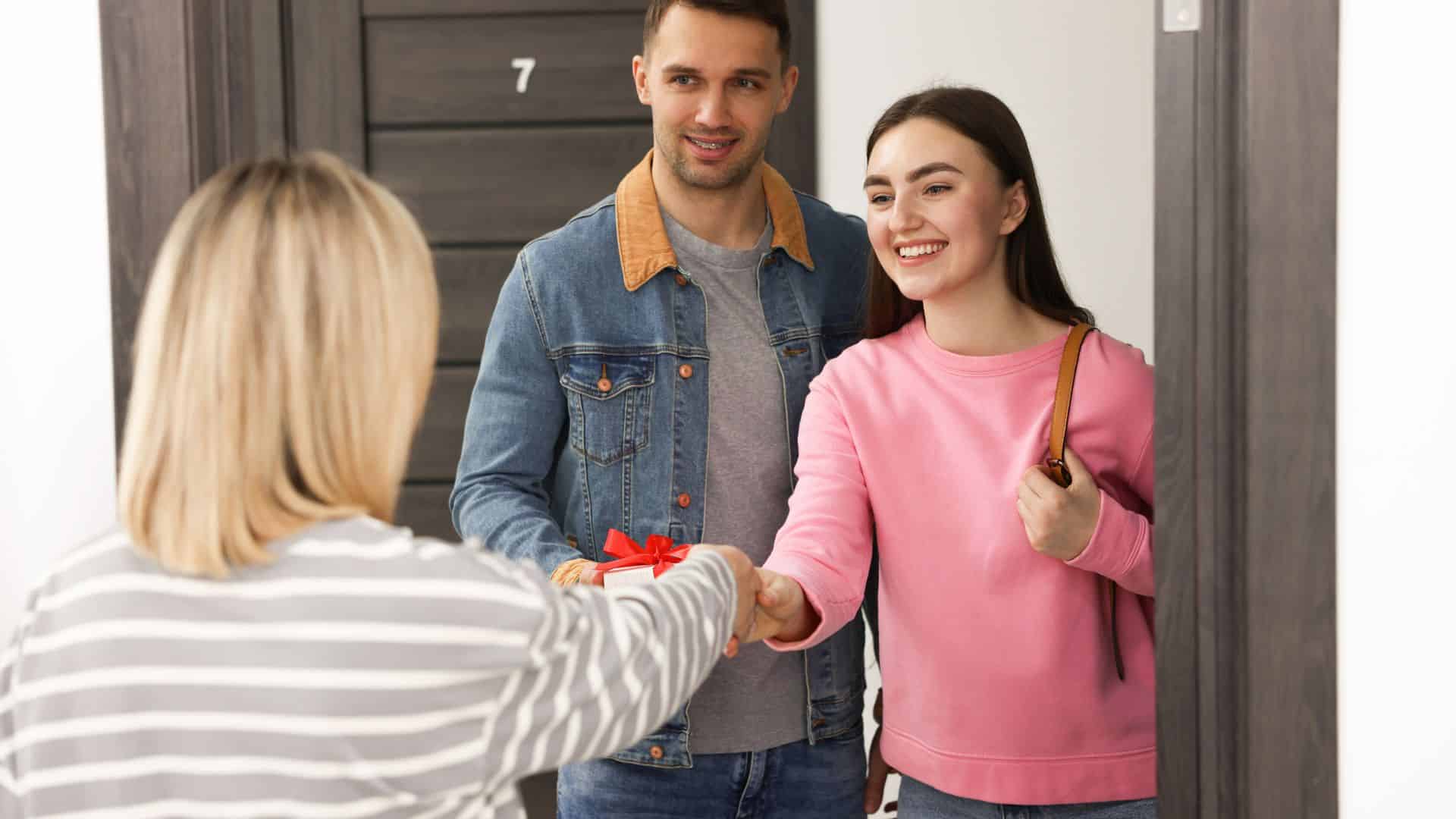 A young man and woman greeting their neighbor