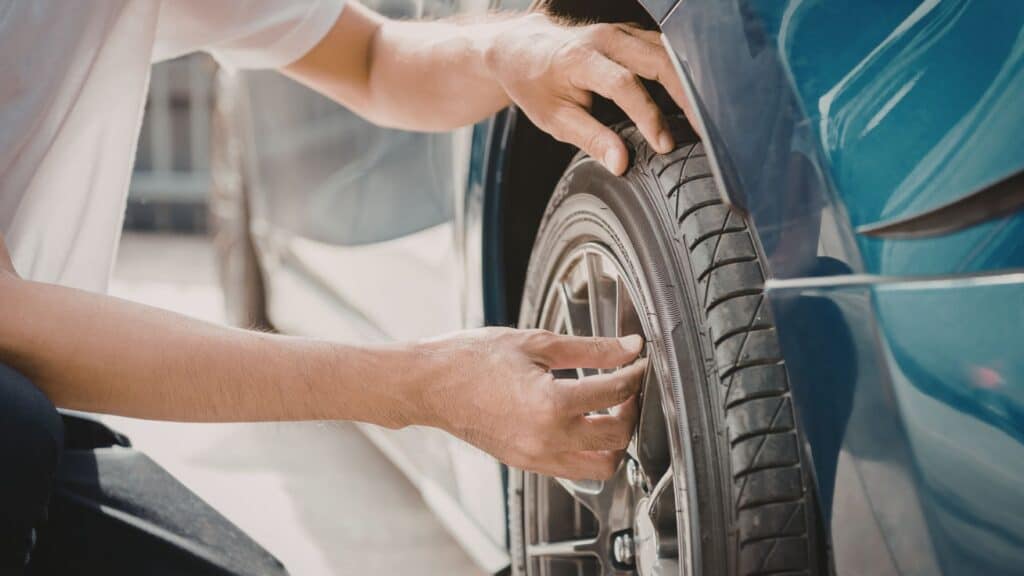 A man putting the cap back on the valve stem of his tire