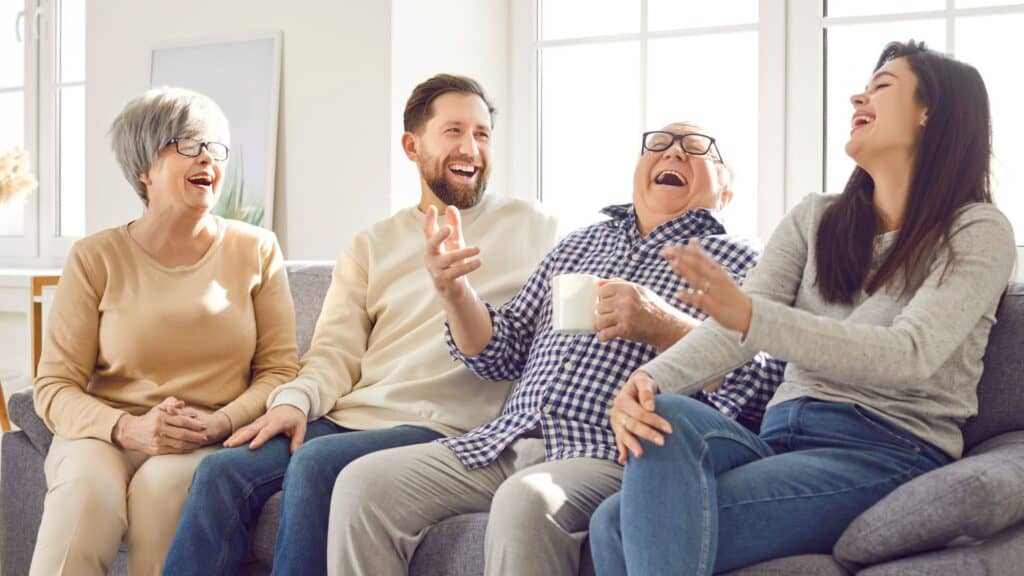 A family sitting on the couch laughing and talking together