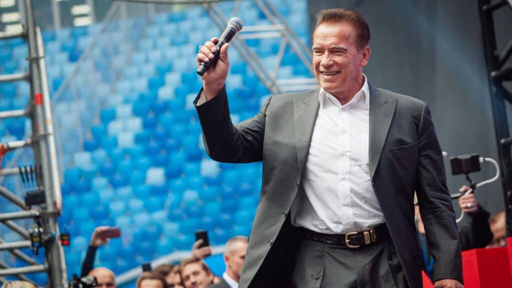 Arnold Schwarzenegger holding the mic on stage