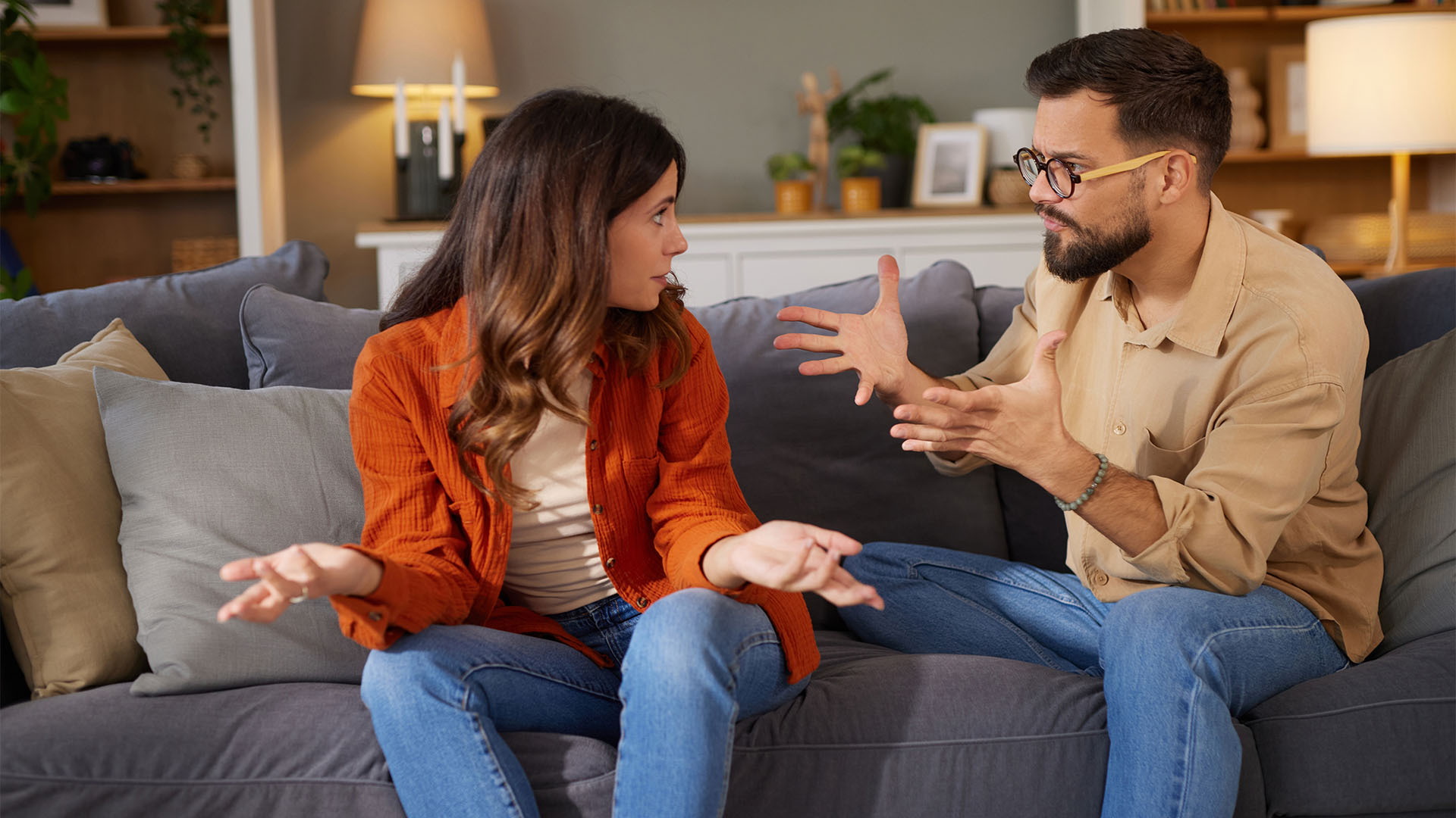 Couple talk on a sofa.