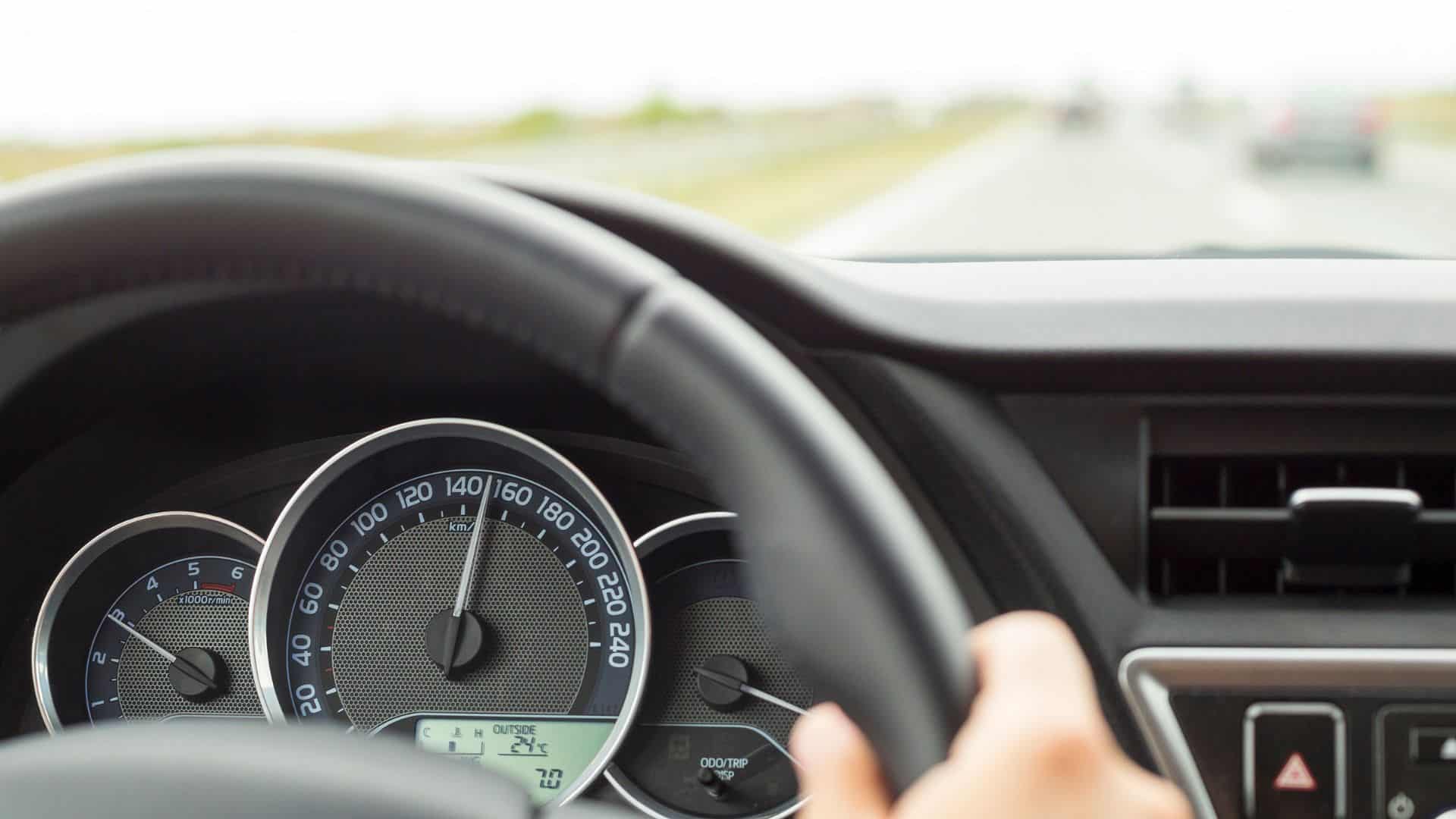 Man with hands on steering wheel driving