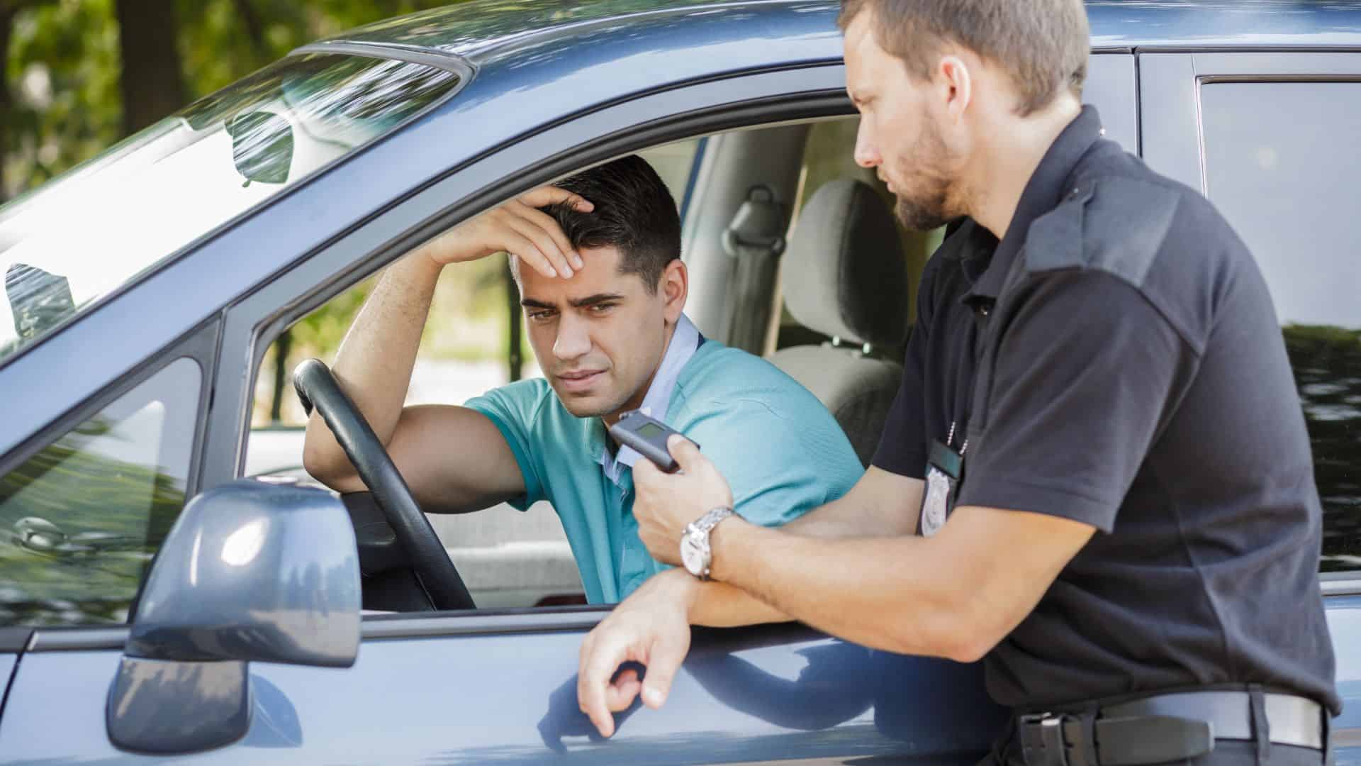Police officer issuing speeding ticket to driver inside a car