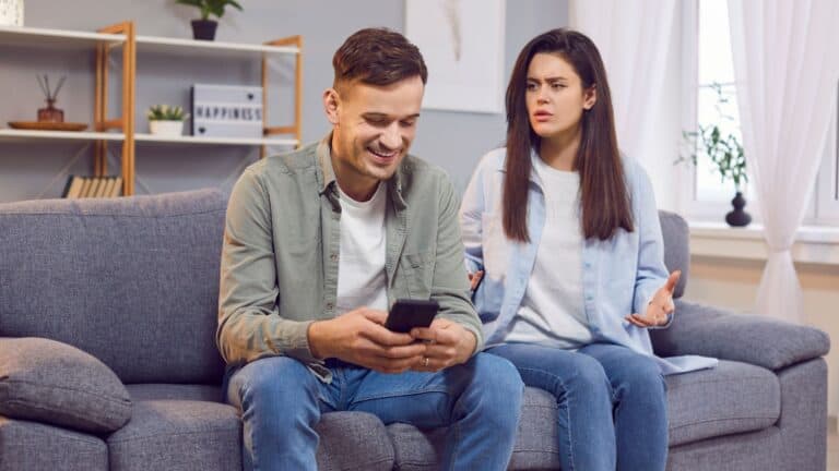 Man looking at cellphone ignoring woman.