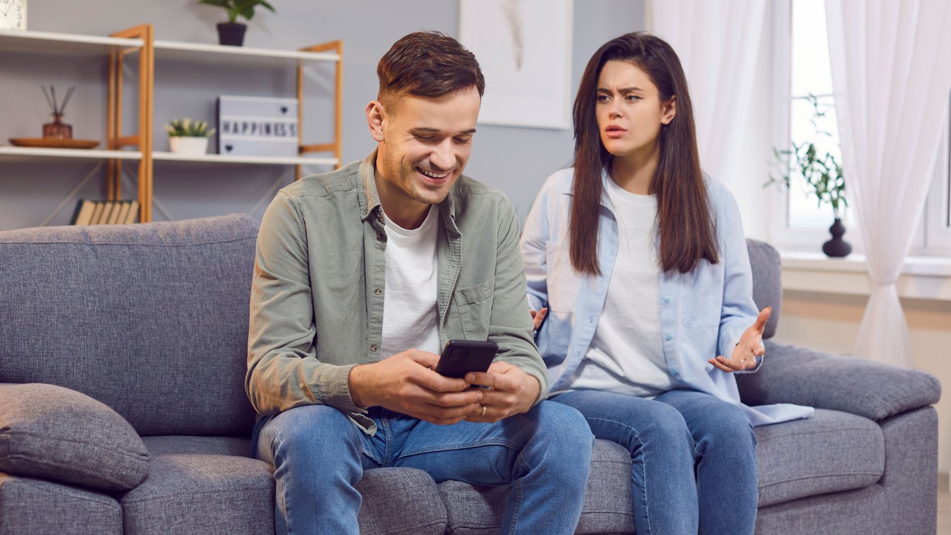 Man looking at cellphone ignoring woman.
