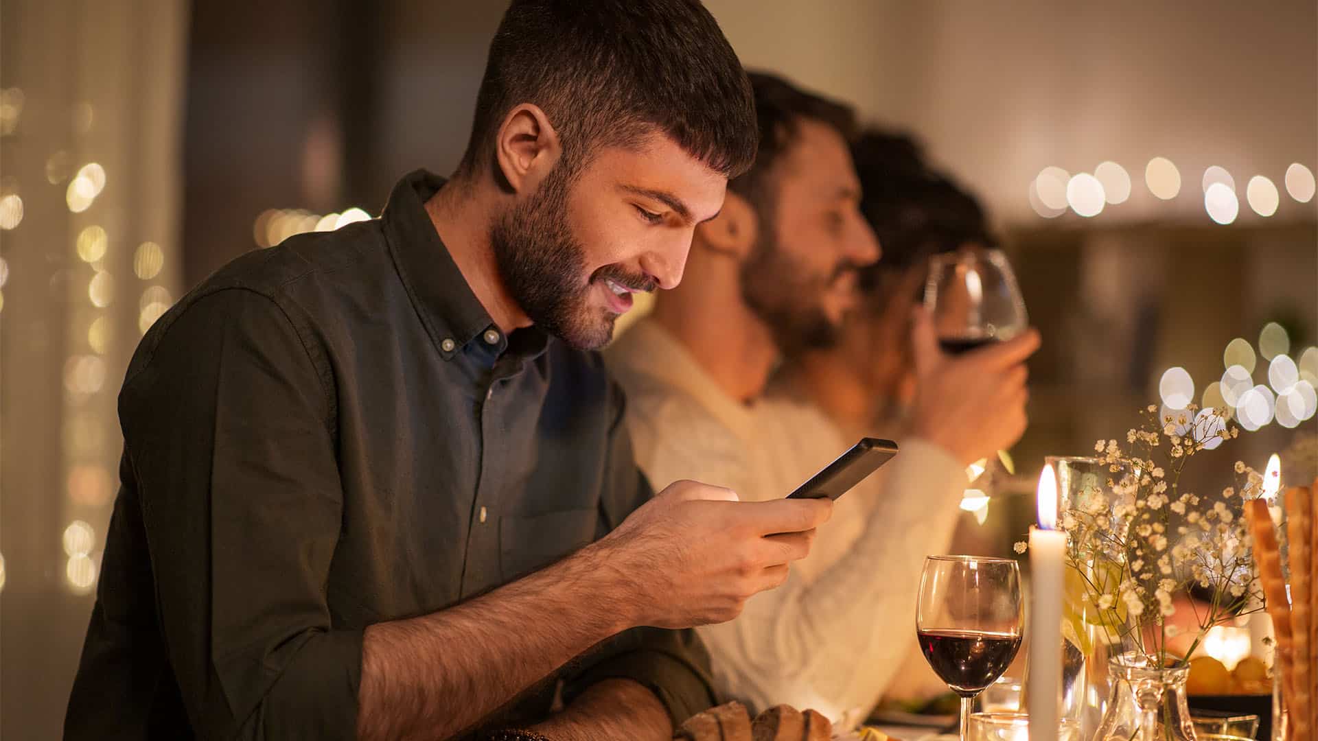 Man on a phone during dinner.
