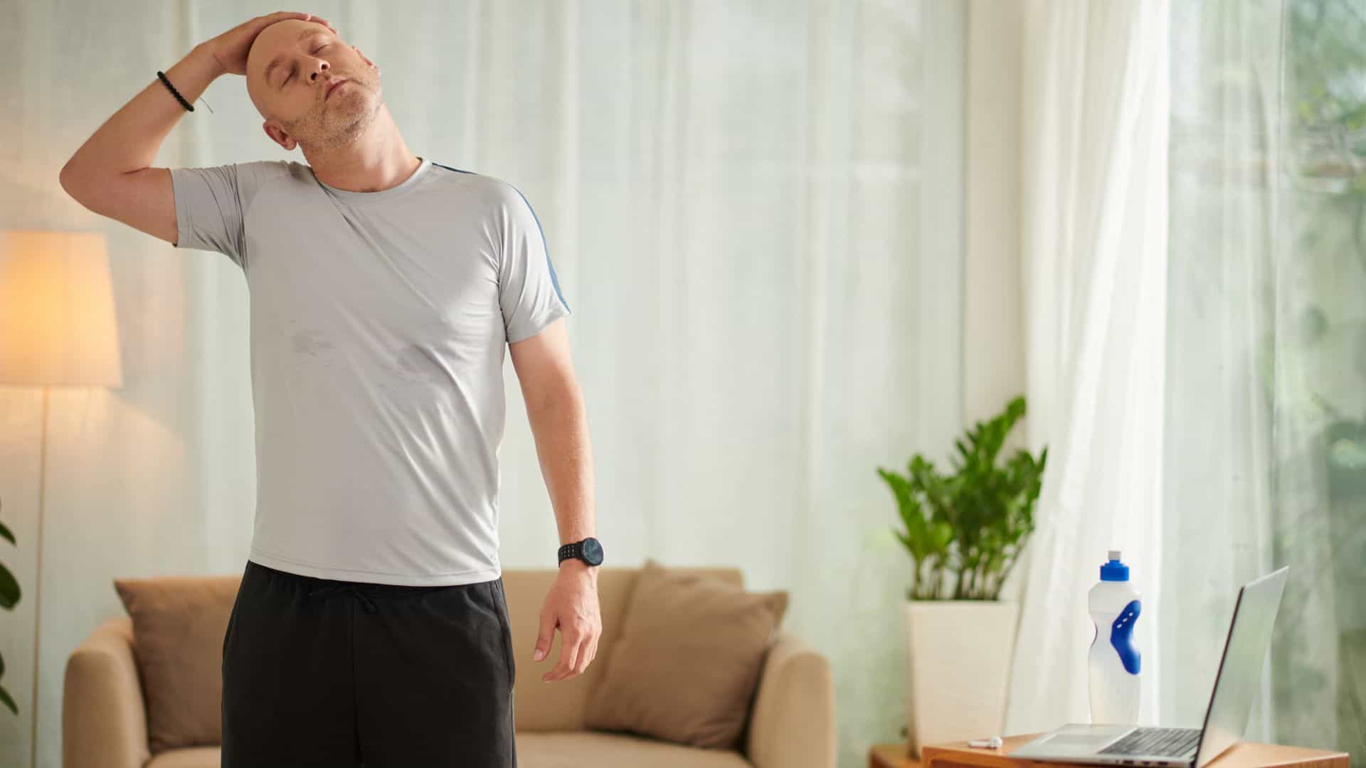 A man stretching at home in his living room
