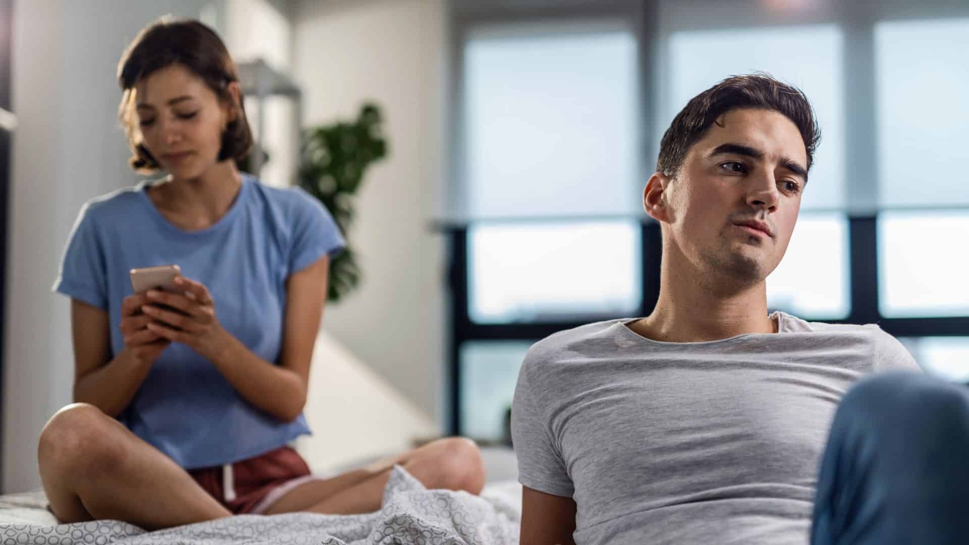 Woman using her phone ignoring man
