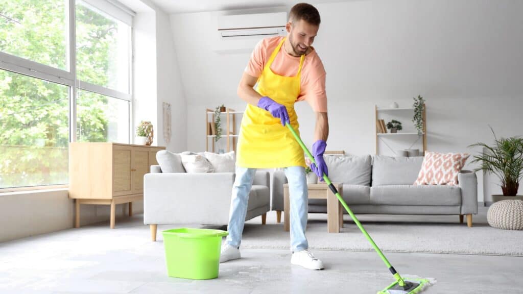 A man mopping his floors with gloves on