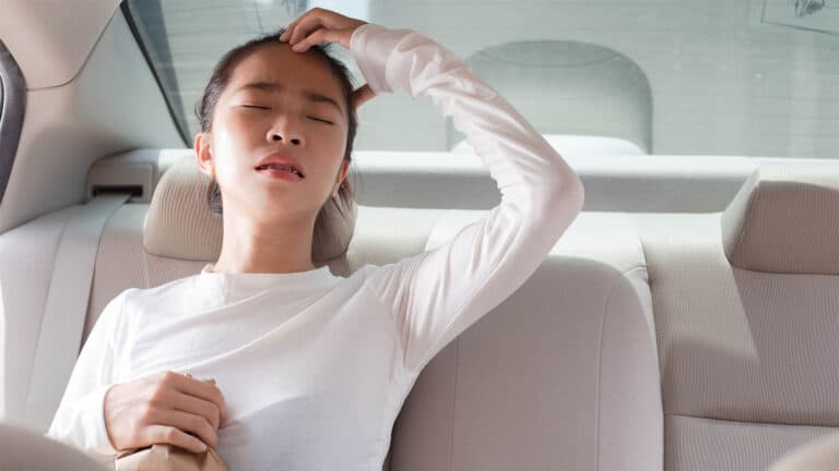 A woman has a headache in a car