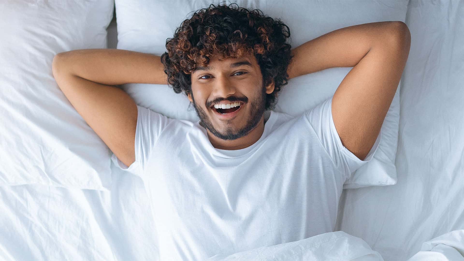Happy man in bed.