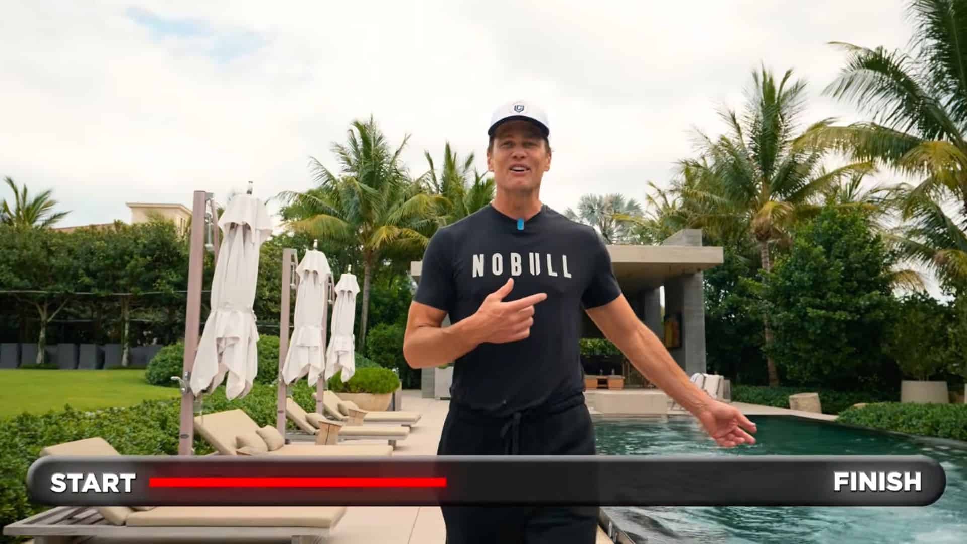 Tom Brady walks next to his swimming pool