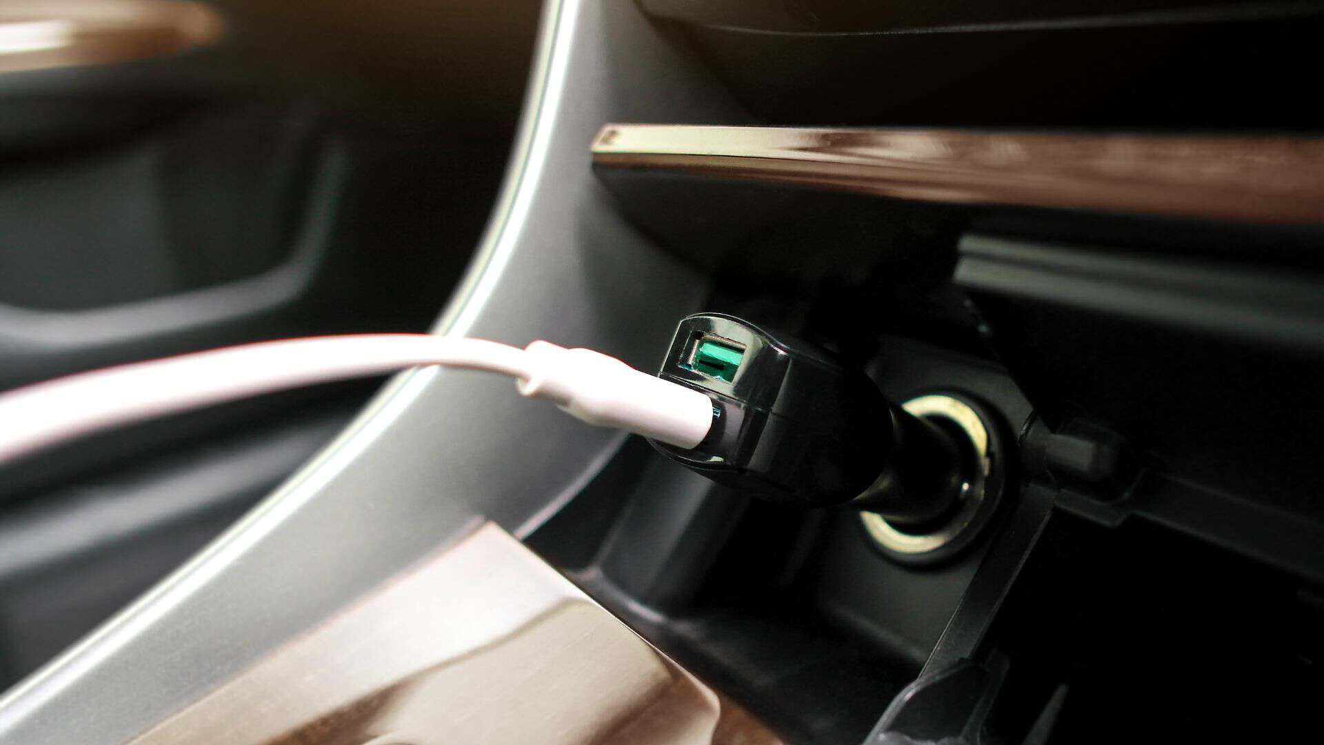 A phone charger plugged into a car USB port