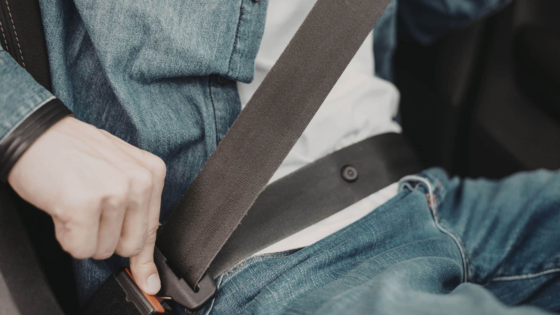 A man putting on his seatbelt