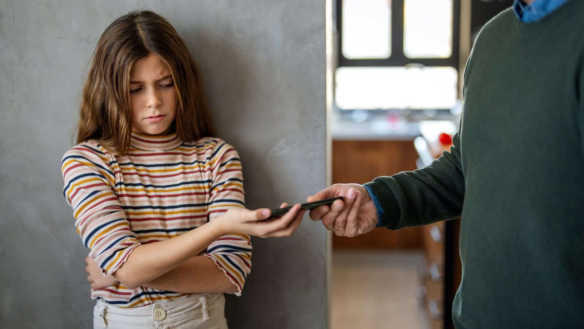 man taking phone from his daughter