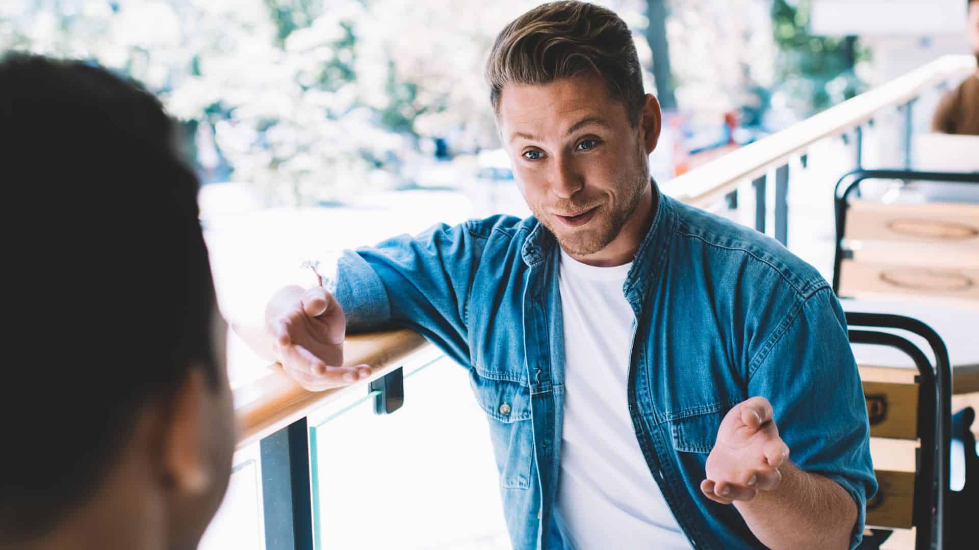 A man explaining something to a friend over lunch
