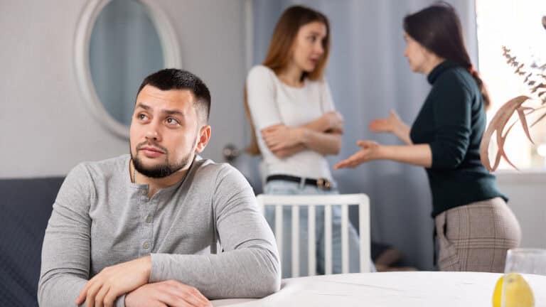 Women argue, and a man is watching.
