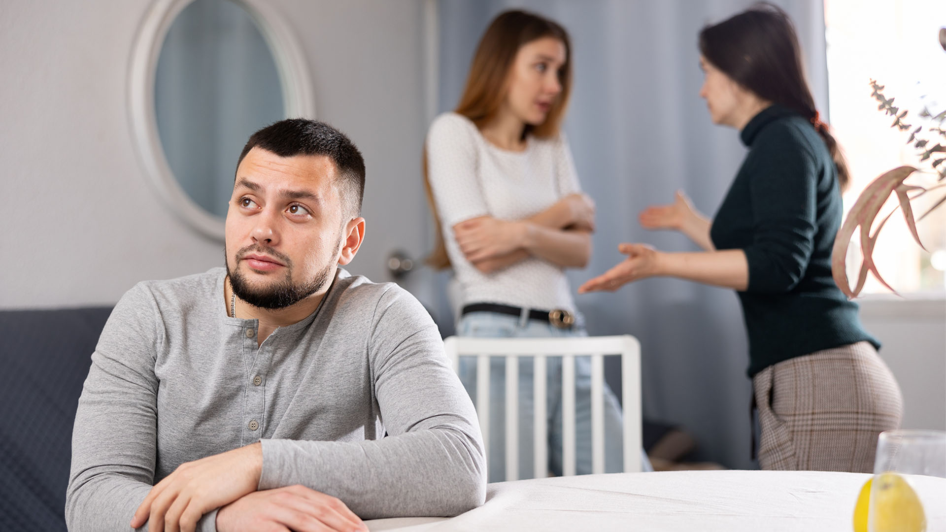 Women argue, and a man is watching.